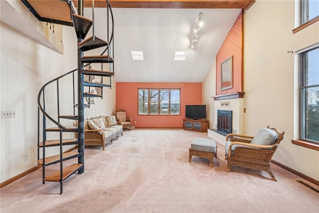 living room with rail lighting, high vaulted ceiling, carpet flooring, and a textured ceiling