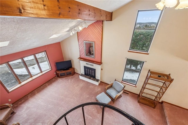 living room featuring a wealth of natural light, lofted ceiling, carpet floors, a large fireplace, and a textured ceiling