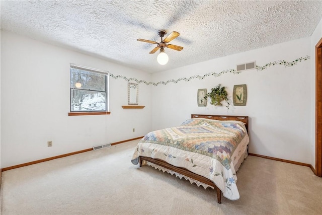 bedroom with ceiling fan, a textured ceiling, and carpet flooring