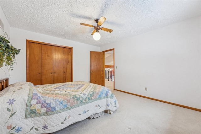 carpeted bedroom featuring ceiling fan, a closet, and a textured ceiling