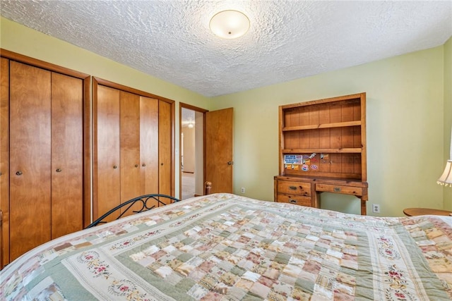 bedroom featuring multiple closets and a textured ceiling