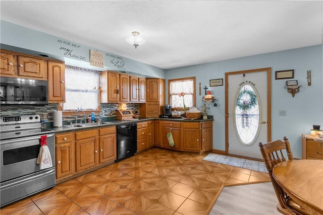 kitchen featuring sink, decorative backsplash, a textured ceiling, and appliances with stainless steel finishes