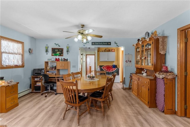 dining area with ceiling fan, a baseboard radiator, and light wood-type flooring