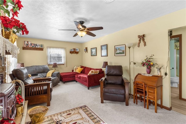 living room with light carpet, a textured ceiling, and ceiling fan