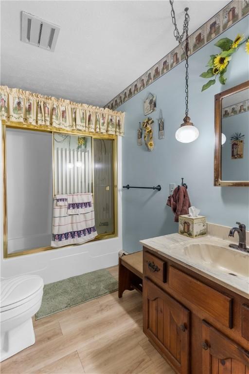 full bathroom featuring vanity, wood-type flooring, tub / shower combination, and toilet