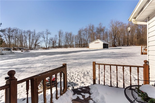 yard layered in snow with an outdoor structure