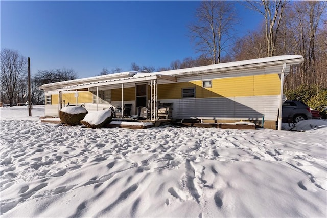 view of snow covered back of property