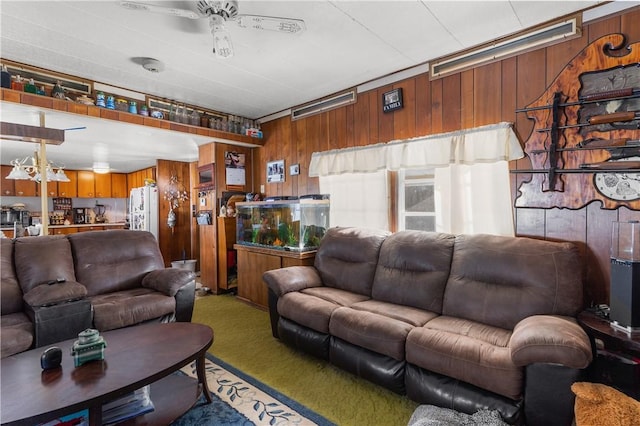 living room featuring carpet floors, ceiling fan, and wood walls