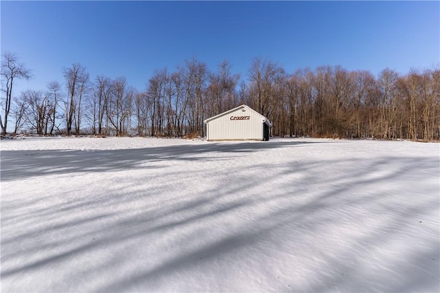 yard layered in snow featuring an outbuilding