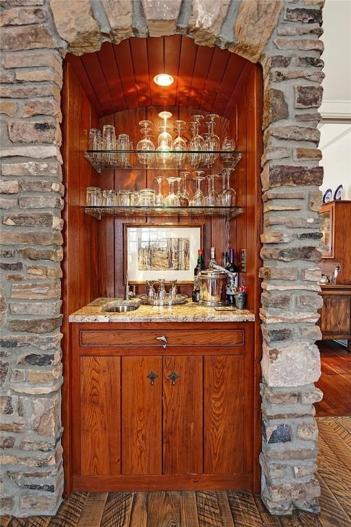bar featuring a sink, vaulted ceiling, bar area, and wooden ceiling