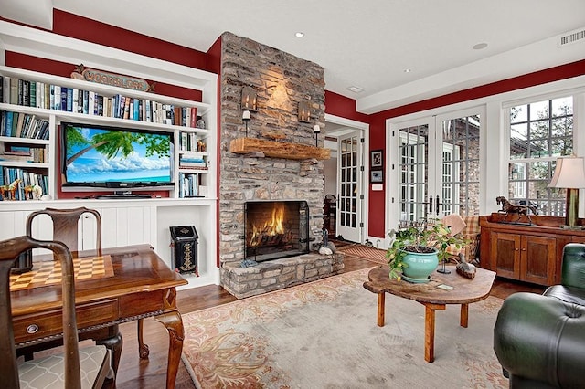 living room featuring hardwood / wood-style flooring, a fireplace, and french doors