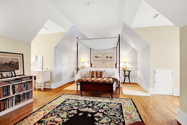 bedroom with vaulted ceiling and light wood-type flooring