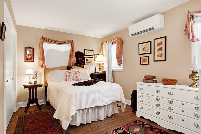 bedroom with a wall mounted air conditioner and dark hardwood / wood-style floors