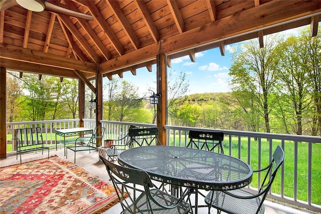 deck with outdoor dining space and a yard