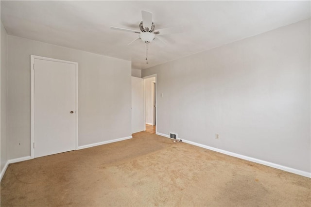 unfurnished room with light colored carpet and ceiling fan