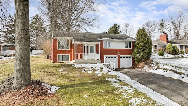 split foyer home with a garage and a lawn