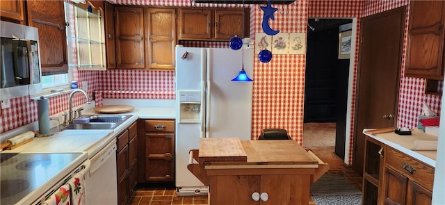 kitchen featuring pendant lighting, white dishwasher, and sink