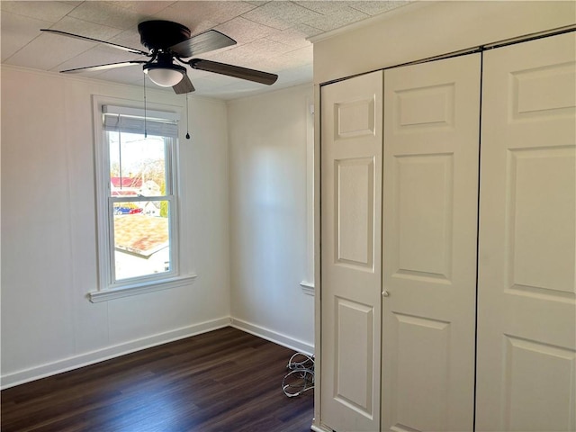 unfurnished bedroom featuring a closet, dark hardwood / wood-style floors, and ceiling fan