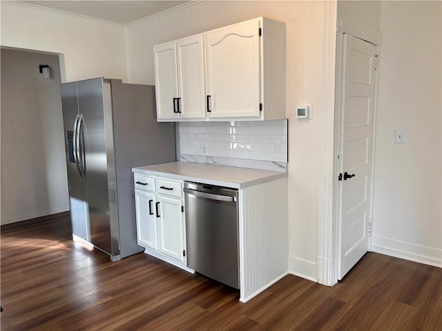 kitchen with dark hardwood / wood-style flooring, backsplash, white cabinets, and appliances with stainless steel finishes