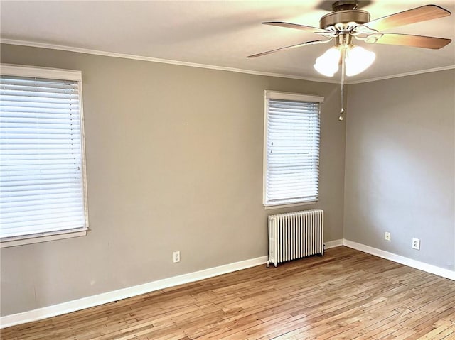 empty room with crown molding, a healthy amount of sunlight, radiator heating unit, and light hardwood / wood-style flooring