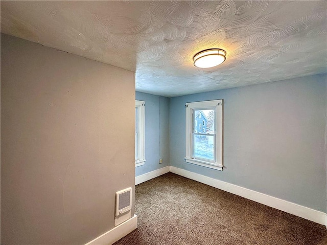 carpeted spare room with a textured ceiling