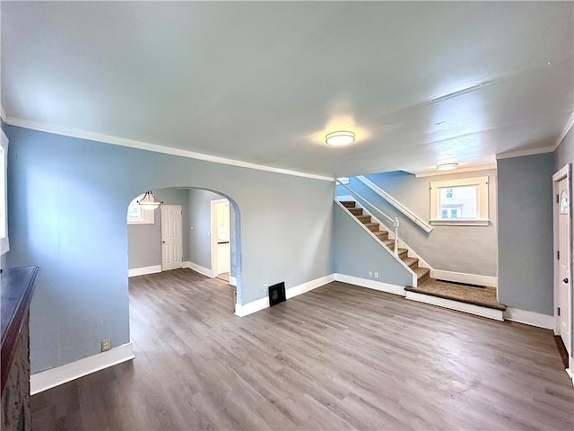 unfurnished living room with ornamental molding and wood-type flooring