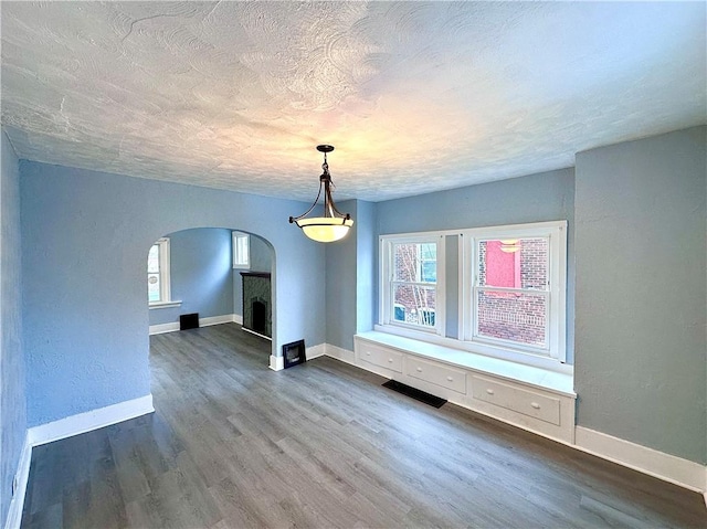 unfurnished living room featuring dark hardwood / wood-style flooring and a textured ceiling