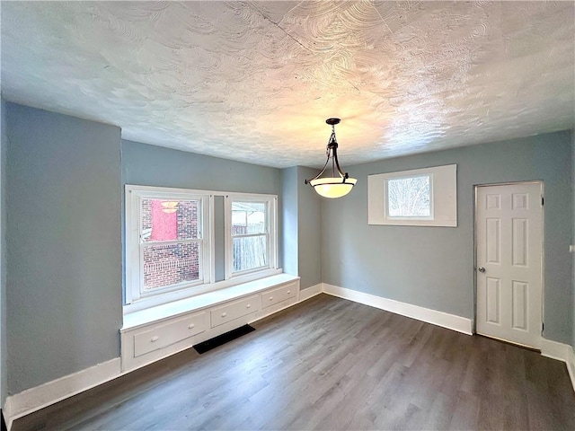 unfurnished room with dark hardwood / wood-style flooring and a textured ceiling