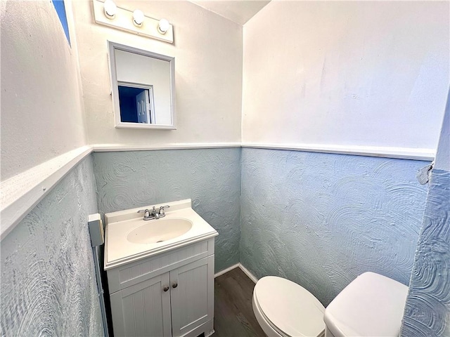 bathroom with vanity, hardwood / wood-style floors, and toilet