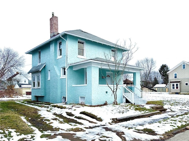 view of snow covered rear of property