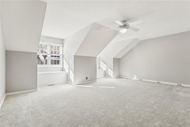 additional living space featuring lofted ceiling, light carpet, and ceiling fan