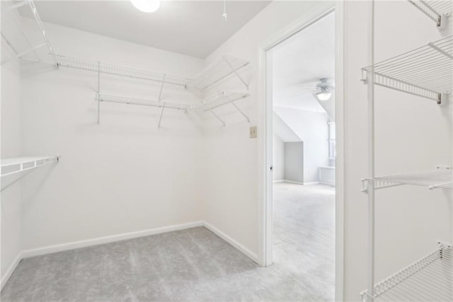 spacious closet with light carpet and ceiling fan