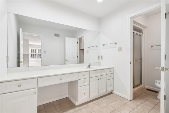 bathroom with vanity, toilet, tile patterned floors, and walk in shower