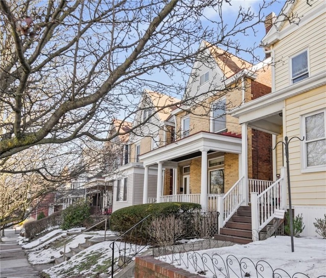 view of snowy exterior with a porch