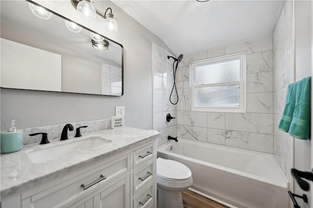 full bathroom with tiled shower / bath, vanity, and toilet