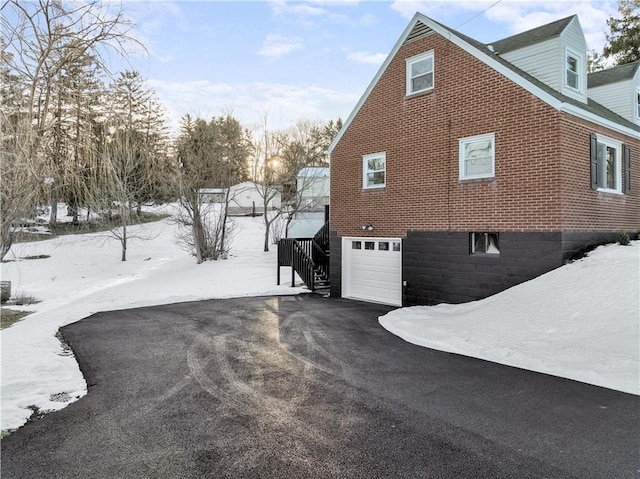 view of snow covered exterior with a garage