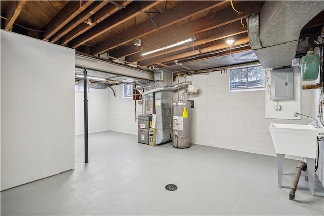 basement featuring electric panel, heating unit, and gas water heater