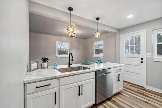 kitchen with sink, light stone counters, white cabinets, decorative light fixtures, and stainless steel dishwasher