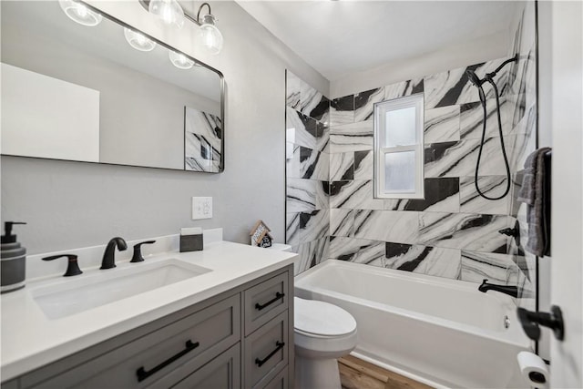 full bathroom with tiled shower / bath, vanity, and toilet