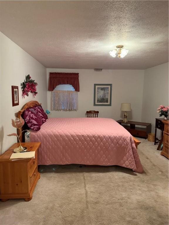 bedroom featuring light carpet and a textured ceiling