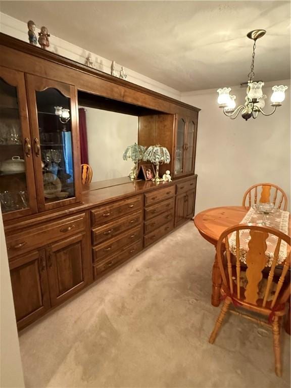 living area with an inviting chandelier and light colored carpet