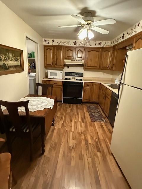 kitchen with ceiling fan, washer / dryer, dark wood-type flooring, and white appliances