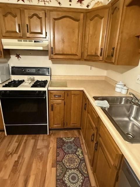 kitchen with gas stove, sink, and light hardwood / wood-style flooring