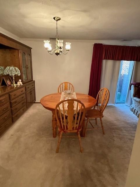 carpeted dining space with an inviting chandelier and ornamental molding