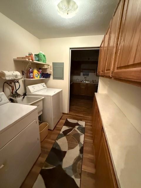 washroom featuring cabinets, sink, a textured ceiling, and independent washer and dryer