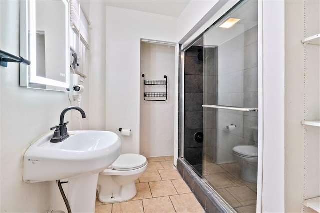 bathroom featuring tile patterned flooring, a shower with door, and toilet