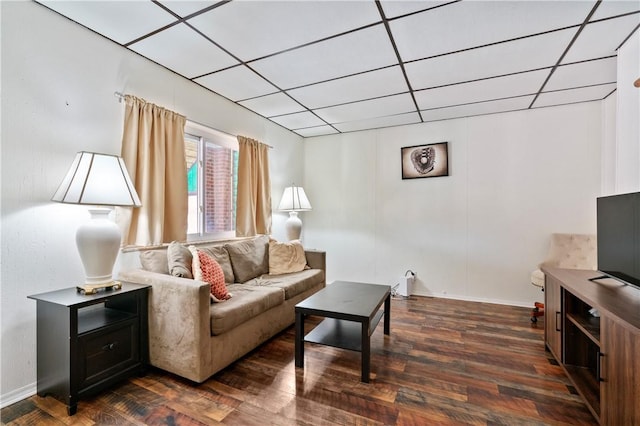 living room with a drop ceiling and dark hardwood / wood-style floors