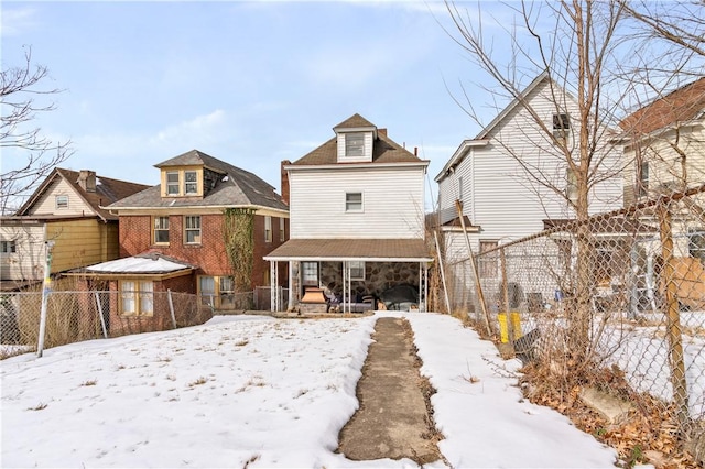 snow covered back of property with covered porch