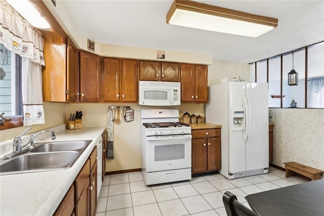 kitchen featuring white appliances, sink, and light tile patterned floors