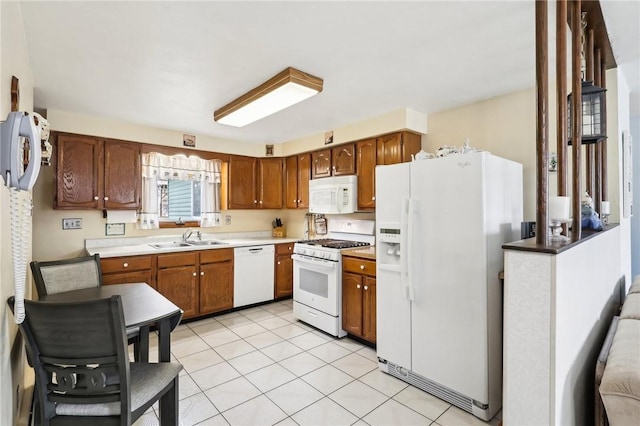 kitchen featuring light tile patterned flooring, sink, and white appliances